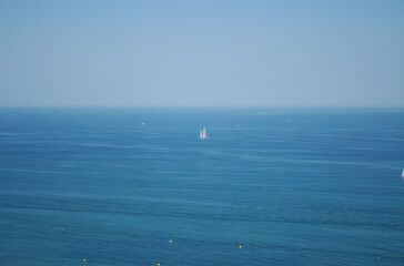 Obraz premium blue sea and blue sky, sky and sea have the same color, gentle waves, blue sky and a white boat