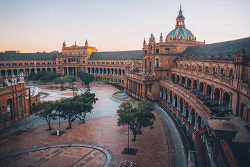 Obraz premium Historic architecture in Seville showcasing beautiful courtyard at sunset with trees and warm lighting