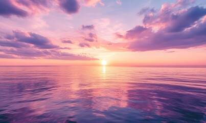Fototapeta premium The pink and purple sky over the sea, the sun sets on the horizon, the calm water reflects the colorful clouds in the distance