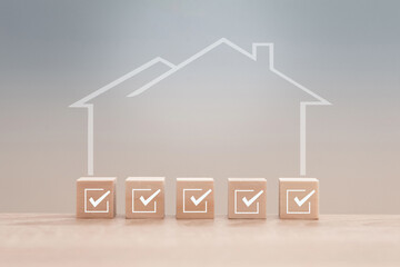 Wooden cubes with checkmarks symbolize successful buying, renting or investing in real estate