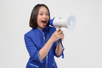 Energetic Asian customer service woman in blue uniform shouting at megaphone to give a speech.