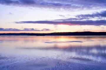 Serene winter sunset over a frozen lake.