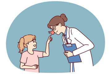 Woman doctor with red nose leans towards little girl for concept of treating children in pediatric clinic. Doctor wants to cheer up child and provide psychological support conducive to recovery