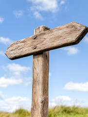 Rustic wooden signpost outdoors, sunny sky