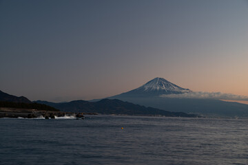 朝焼けの富士山を海岸から眺める