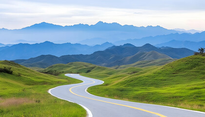 Naklejka premium Winding road through green hills and distant mountains