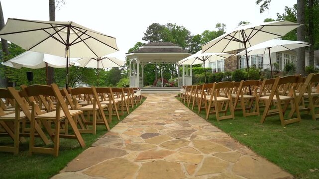 Beautiful outdoor wedding ceremony set up with wooden folding chairs by pond