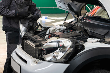 Serviceman repair headlight in car service