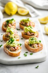 Minimalistic Presentation of Mini Toasts with Mashed Avocado, Tuna, and Lemon Juice on a White Marble Plate