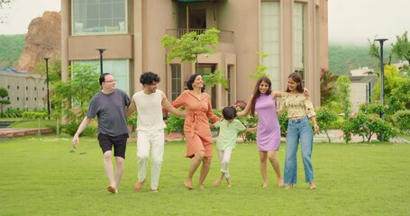 Indian happy family group dancing with teen girl child cute son kid boy enjoy day outdoor home park. Adult mom dad man woman young male female have fun joy play game spend time at outside garden house - Powered by Adobe