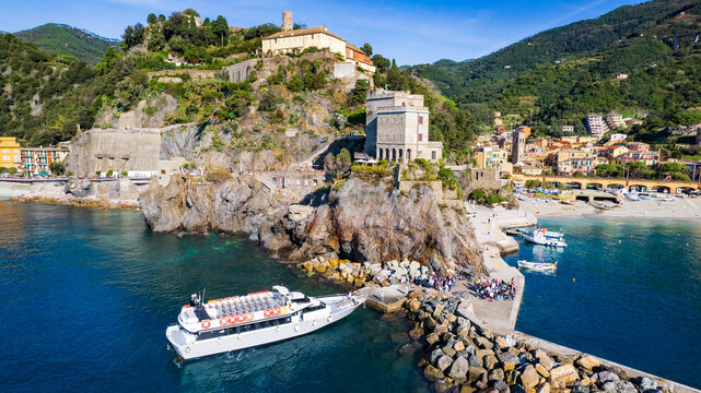 Italy, Cinque terre national park. Monterosso al mare village , beautiful summer destinaltion with stunning beaches and scenic views. Aerial view of touristic boat, castle and the beach