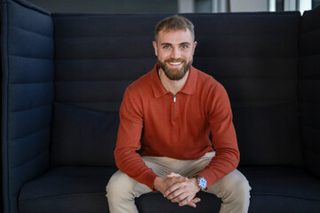 Young man smiling in a modern office setting