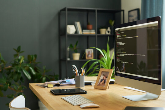 Workplace of coder with developing script on computer monitor at modern office