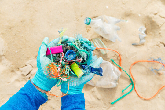 Hands holding collected ocean waste during a beach clean up on the North Sea