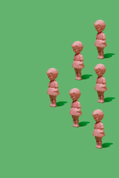 Vintage pink dolls in triangular formation on green background