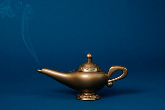 Magic lamp with smoke in a studio setting on a blue background