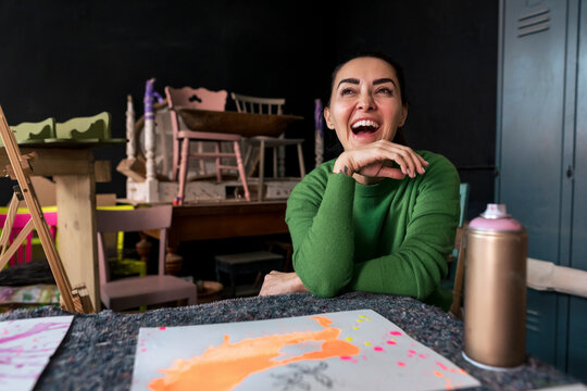 Mature woman in art studio smiling and looking at camera