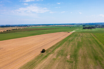 Obraz premium Aerial view an agricultural field, tractor tilling land. Smooth lines plowed soil emphasize scale agricultural work. Farmers labor, preparation for planting season, agricultural development.