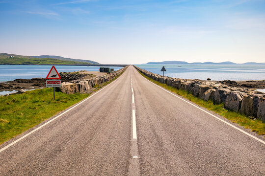 Scenic view of Eriskay Causeway in South Uist, Scotland during summer with a warning sign for otters crossing