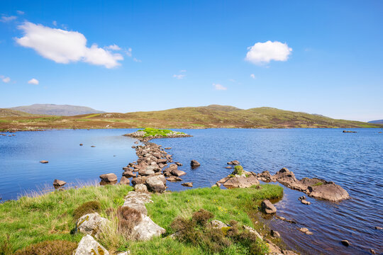Scenic view of Mill Loch with causeway and islet in South Uist, Scotland