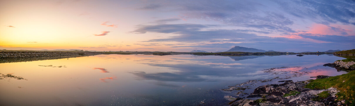 Golden hour sunset over North Uist in the Western Isles of Scotland with magical atmospheric light and colorful reflections.