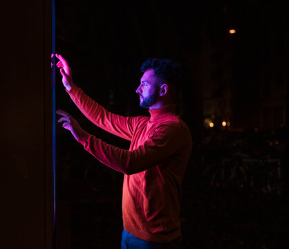 Man wearing red t-Shirt and touch screen kiosk at night