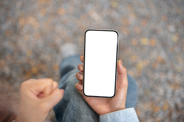 Close up of the right hand holding smartphone with left hand make a fist while sitting cross legged.