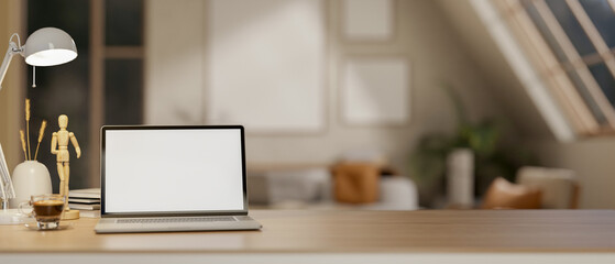 A white screen laptop on wooden table under the lamp light and moon light. Study or working at night.