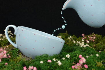 Mysterious garden at night: blue cup with pink dots and blue pearls in motion instead of tea...