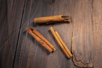 Dried cinnamon sticks placed on a rustic wooden table. A warm and aromatic spice commonly used in Indonesian cuisine, enhancing the flavor of Eid dishes and festive meals with its rich