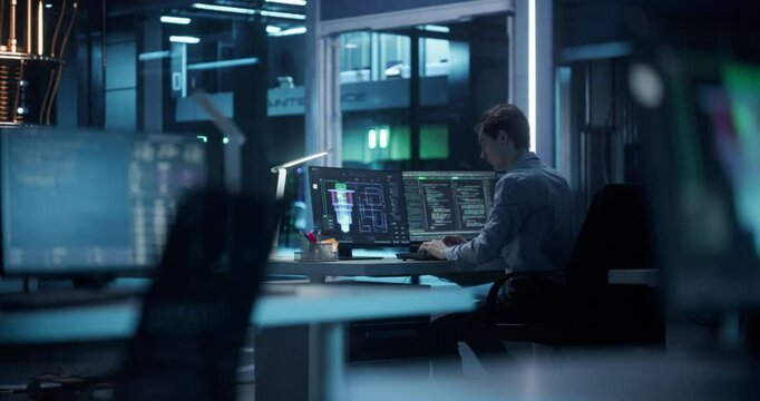 Young Software Developer Working Behind a Desk on a Computer. Engineer Optimizing Software Code of a Quantum Processor, Building a Visual Model of the Quantum Computing Architecture