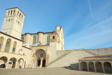 Obraz premium Basilica of Saint Francis of Assisi (Basilica di San Francesco d’Assisi) with the entrance to the lower basilica, seen from the lower square (Piazza Inferiore di San Francesco). Assisi, Italy.