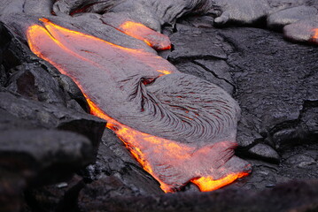 Detail of hot magma flowing over old lava field