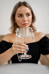 An Elegant Woman Holding a Beautiful Decorative Glass Cup Adorned with Exquisite Jewelry
