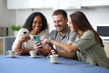 Happy interracial friends checking their smart phones