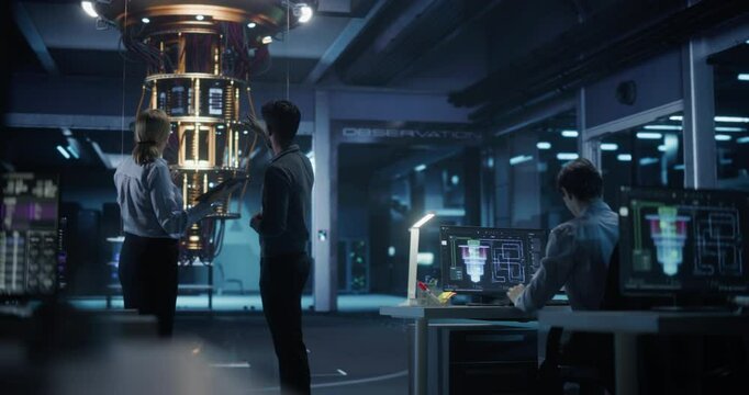 In an Advanced Science Lab, Diverse Engineers Discussing a Quantum Computer Project, Analyzing Data on a Computers. Team of Female and Male Specialists Working to Develop a Quantum Processor