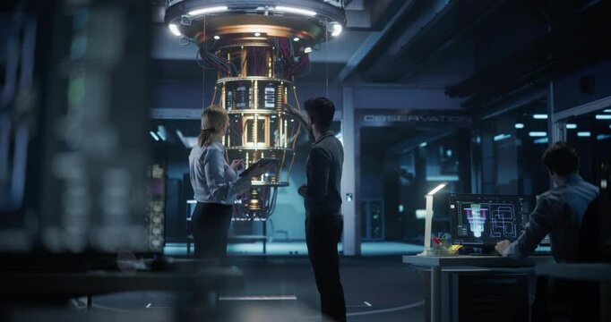 Female and Male Specialists Collaborating on Quantum Computer Development, Discussing a Report on a Tablet Computer in a Research Center. Colleagues Focusing on Innovation and Technology Upgrades