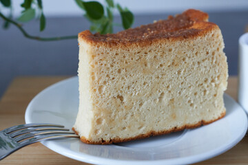 A piece of castella on a white plate with a fork.