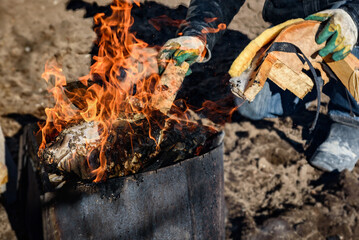 A man burning old unwanted things from home in a bonfire in early spring.