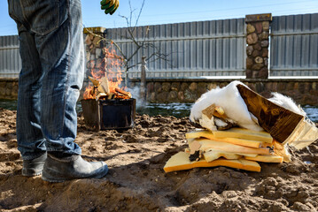 Man burning old sofa in bonfire in early spring.