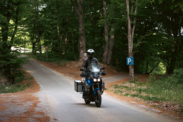 Motorcycle rider on the road in the forest