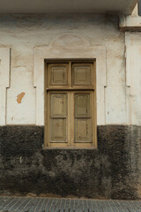 Wooden window on aged two-tone wall