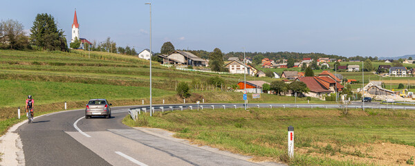 Velika Loka, Slovenia - August 31, 2024: Typical Slovenian village Velika Loka in Trebnje with a white church with red roof on hill top in Slovenia during summertime