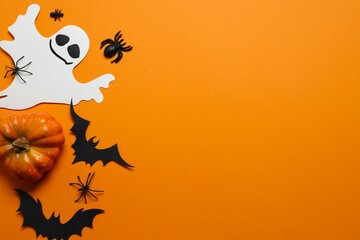 Halloween holiday decorations including pumpkins, spiders, bats on orange background