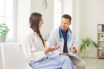 Obraz premium Doctor or nurse conducting a medical consultation with a female patient in a hospital office. Healthcare professional offers medical advice and support, ensuring the patient comfort during the visit.