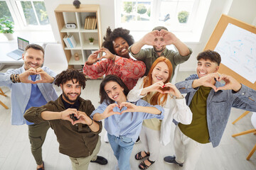 Happy diverse multiethnic office business team, happy coworkers making hand heart gesture, promoting friendship support, charity, volunteering, smiling, success project, employee achievement