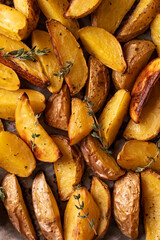 Roasted sliced potatoes with thyme herb background