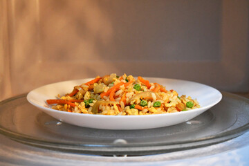 Vegetable egg fried rice leftover reheating in microwave.