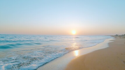 Fototapeta premium Serene beach at sunrise with gentle waves and clear sky, perfect for relaxation and inspiration.