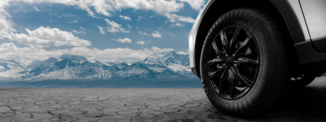 A car tire is shown in front of a mountain range